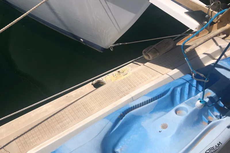 Slide: The Image of Catalina 30 MkIII sailboat docked, showing deck and blue kayak, 1996 model. - 57