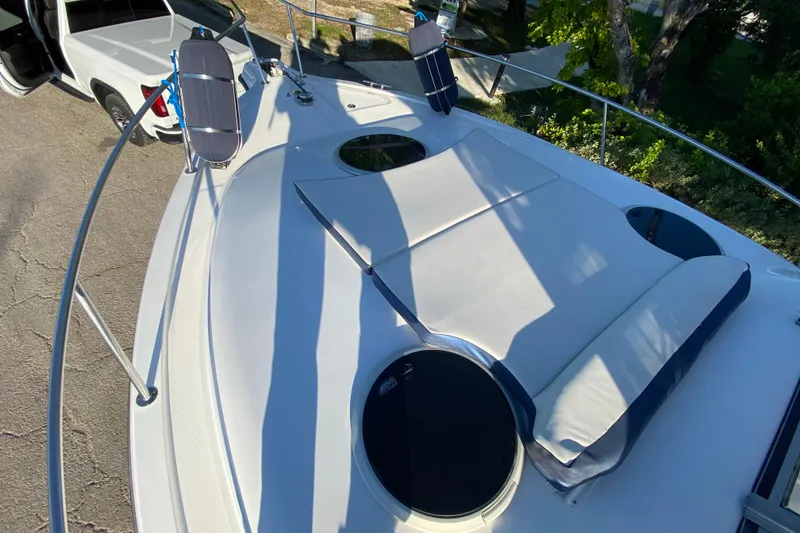 Slide: The Image of 2009 Century 3200 Offshore boat deck with sunbathing cushions and nearby parked vehicle. - 12