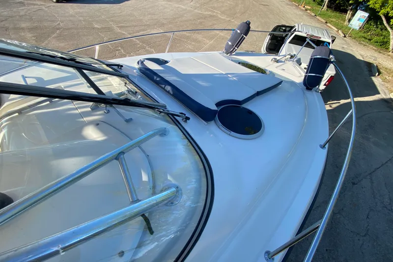 Slide: The Image of 2009 Century 3200 Offshore boat with sleek deck design and windshield, parked on pavement. - 13