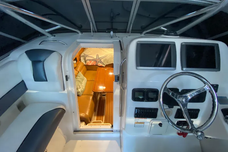 Slide: The Image of 2009 Century 3200 Offshore boat interior with helm, seating, and cabin view. - 24
