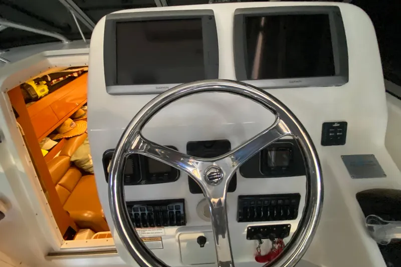 Slide: The Image of 2009 Century 3200 Offshore boat helm with dual Garmin displays and cabin view. - 25