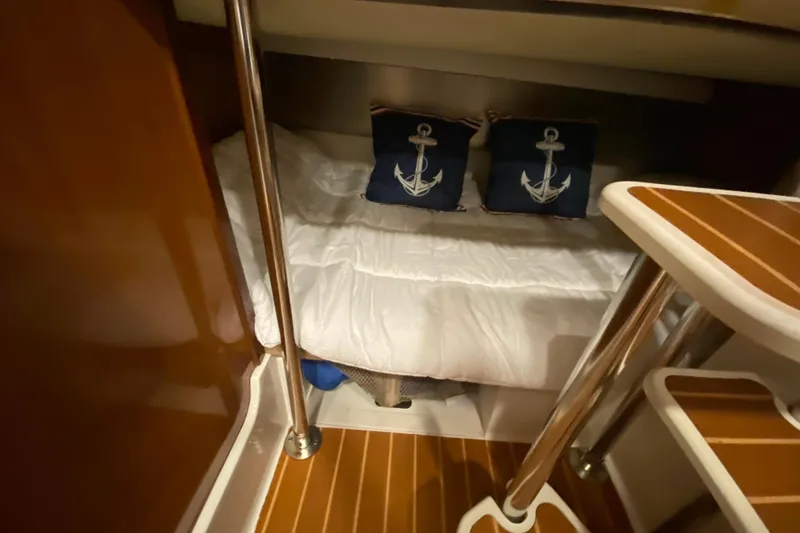 Slide: The Image of Cozy cabin interior of 2009 Century 3200 Offshore with nautical-themed pillows. - 30