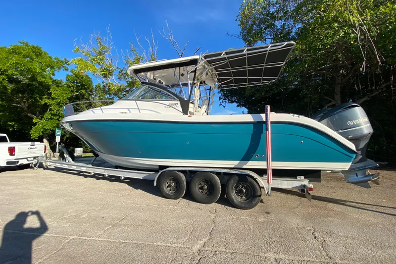 Slide: The Image of 2009 Century 3200 Offshore boat on trailer, parked outdoors with Yamaha engines. - 32