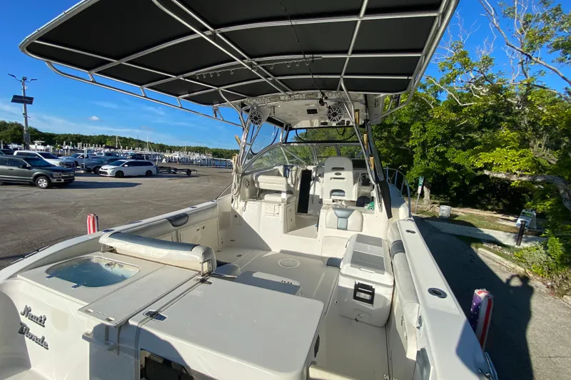 Slide: The Image of 2009 Century 3200 Offshore boat with spacious deck and canopy, parked near marina. - 35