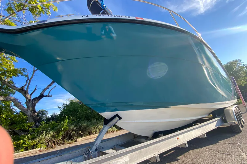 Slide: The Image of 2009 Century 3200 Offshore boat on trailer, vibrant blue hull, sunny day. - 7