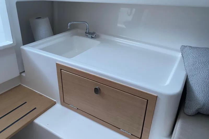 Slide: The Image of Modern sink area in 2025 Nimbus Tender 8 boat, featuring sleek design and wooden cabinetry. - 19
