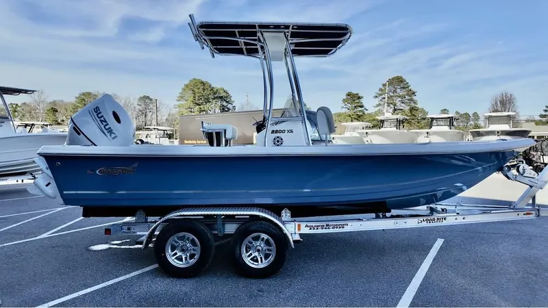 Slide: The Image of 2025 Bulls Bay 2200 XS boat on trailer, blue hull, Suzuki outboard motor. - 4