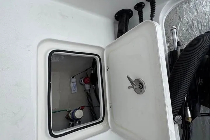 Slide: The Image of Open hatch on 2026 Parker 18SE Center Console boat showing internal components. - 6