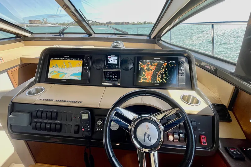 Slide: The Image of 2017 Sea Ray Sundancer 400 helm with navigation screens and steering wheel. - 19