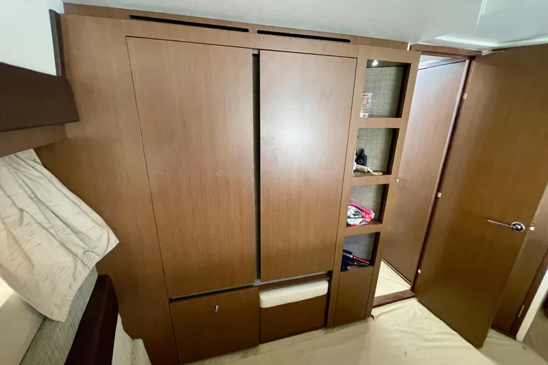 Slide: The Image of 2017 Sea Ray Sundancer 400 interior with wooden cabinetry and open shelving. - 28