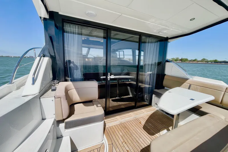 Slide: The Image of 2017 Sea Ray Sundancer 400 yacht interior with seating and table, overlooking the water. - 9