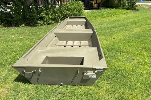 Slide: The Image of 2026 Tracker Grizzly 14 Jon boat on grass, showcasing its sturdy design and spacious interior. - 3