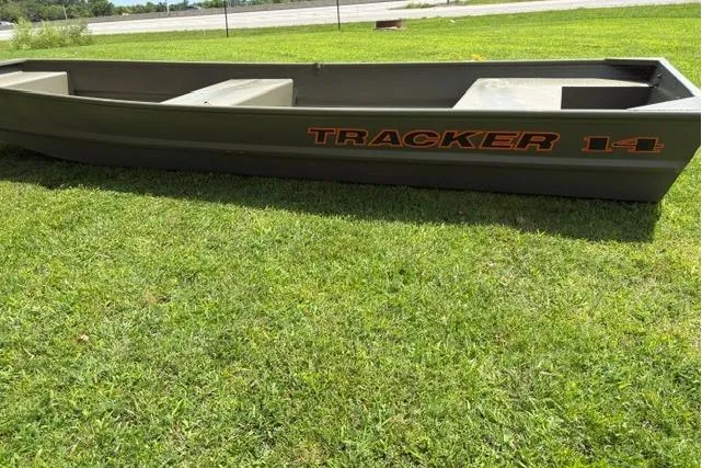 Slide: The Image of 2026 Tracker Grizzly 14 Jon boat on grass, showcasing durable design and spacious interior. - 5