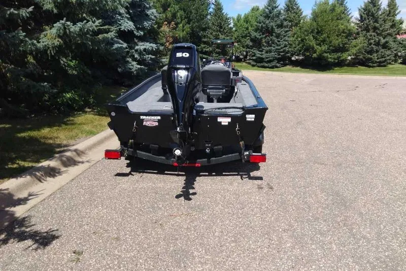 Slide: The Image of 2026 Tracker Super Guide V-16 SC boat on trailer, parked on a sunny road. - 2