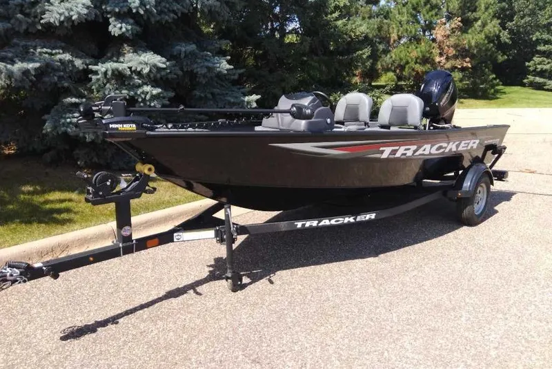Slide: The Image of 2026 Tracker Super Guide V-16 SC fishing boat on trailer, parked outdoors. - 6