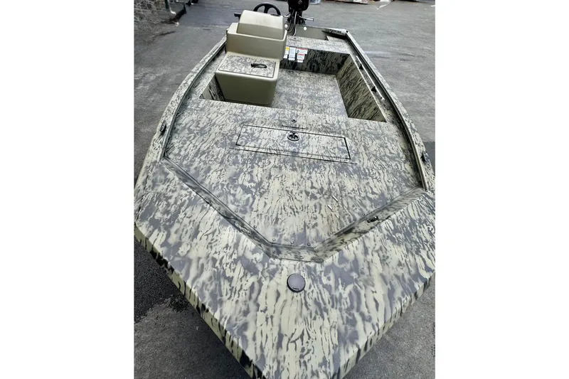 Slide: The Image of 2026 Tracker Grizzly 1648 SC boat with camouflage design on a concrete surface. - 2