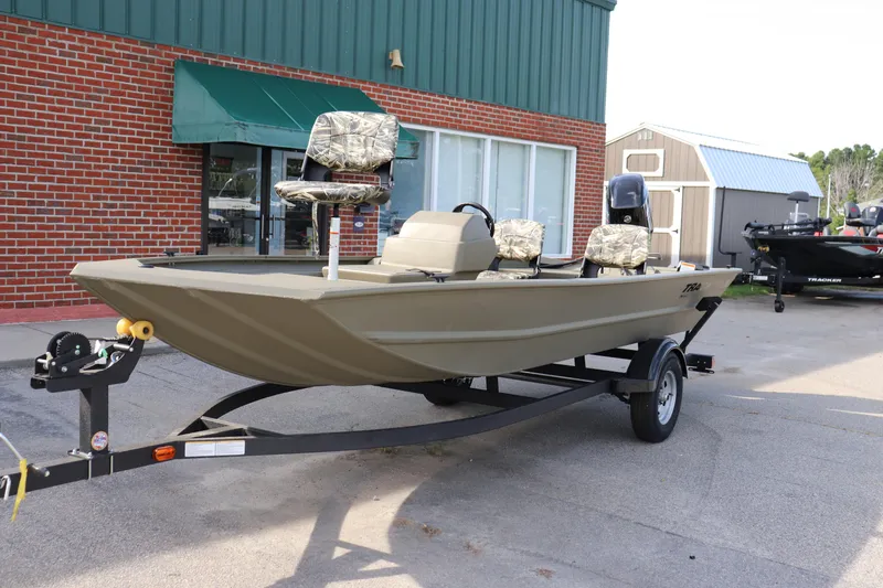 The Image of 2026 Tracker Grizzly 1754 SC boat on trailer, parked outside a building. - 0