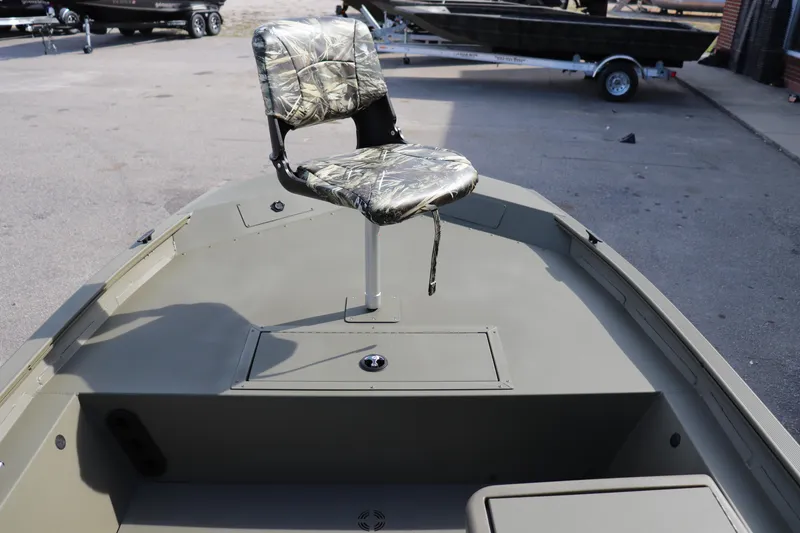 Slide: The Image of 2026 Tracker Grizzly 1754 SC boat with camo seat, parked outdoors. - 2