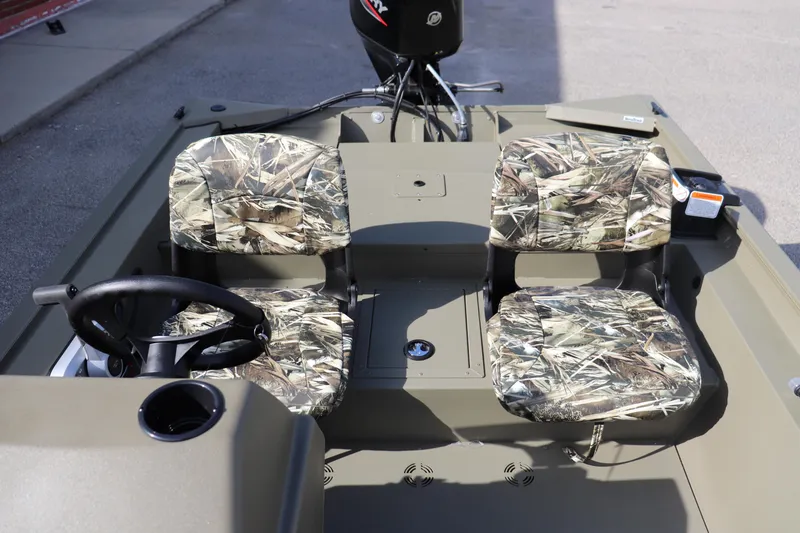Slide: The Image of 2026 Tracker Grizzly 1754 SC boat interior with camo seats and steering wheel. - 3