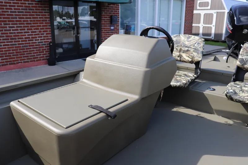 Slide: The Image of 2026 Tracker Grizzly 1754 SC boat interior with camo seats and steering console. - 5