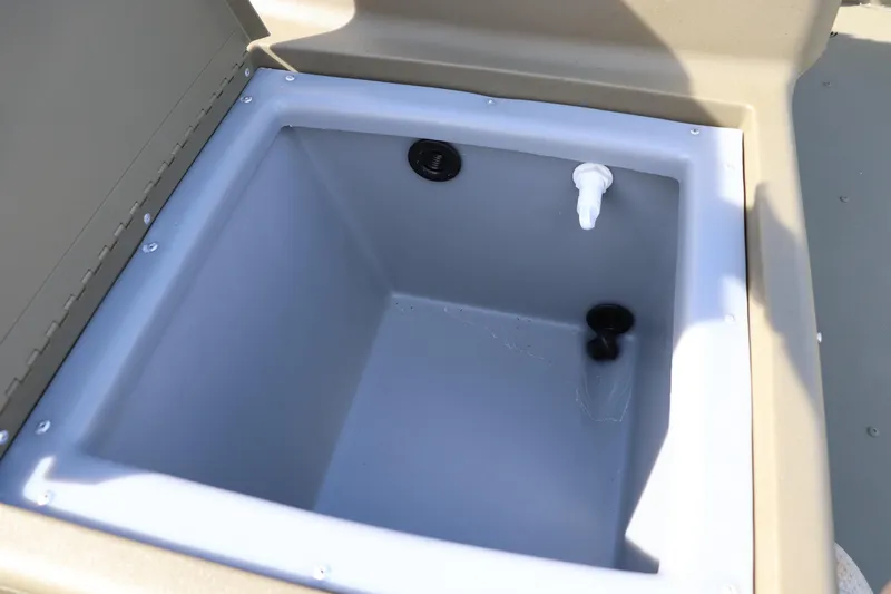 Slide: The Image of Livewell compartment in 2026 Tracker Grizzly 1754 SC boat, featuring drainage and fill ports. - 6