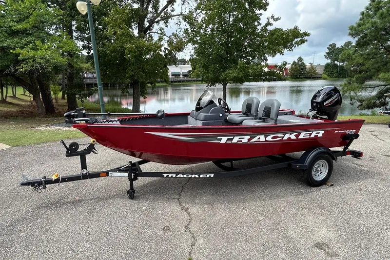 Slide: The Image of 2026 Tracker Super Guide V-16 SC boat on trailer by a lake. - 42