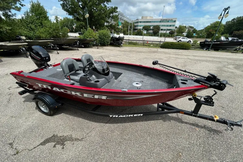 Slide: The Image of 2026 Tracker Super Guide V-16 SC boat on trailer, red exterior, parked outdoors. - 45