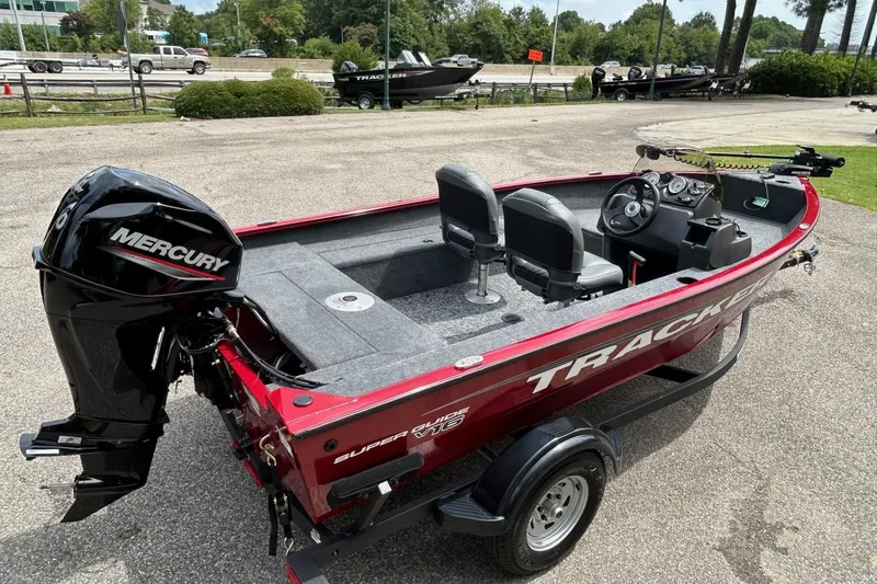 Slide: The Image of 2026 Tracker Super Guide V-16 SC boat with Mercury engine, parked outdoors. - 46