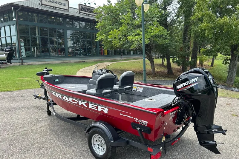 Slide: The Image of 2026 Tracker Super Guide V-16 SC boat with Mercury engine, parked outdoors. - 49
