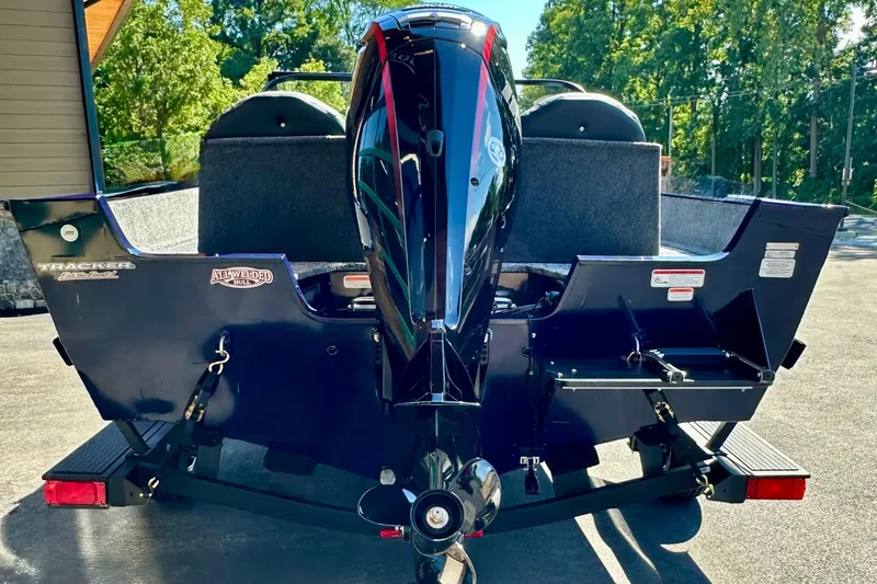 Slide: The Image of 2026 Tracker Pro Team 175 boat rear view with motor, parked outdoors. - 63