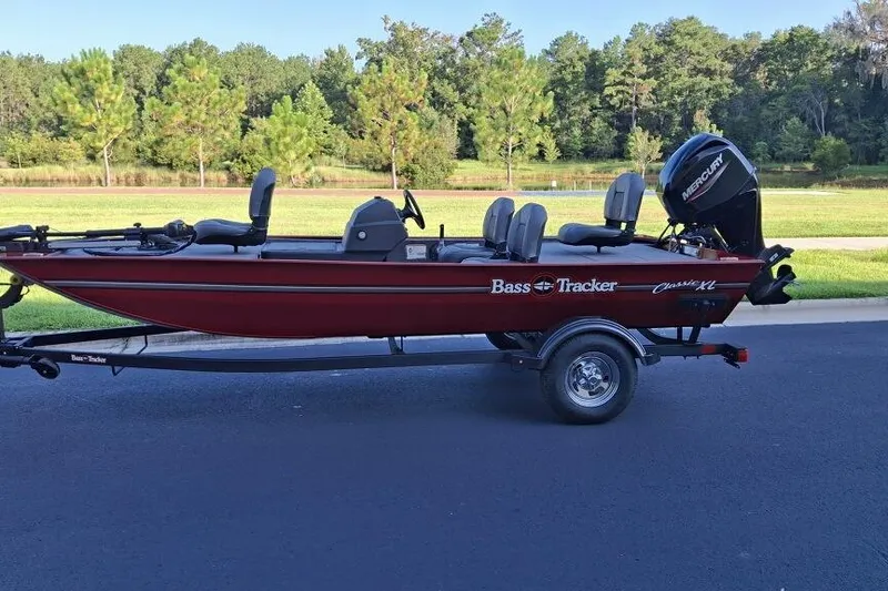 The Image of 2026 Tracker Bass Tracker Classic XL boat on trailer, parked near a scenic lake. - 0