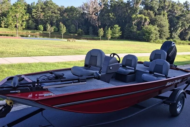 Slide: The Image of 2026 Tracker Bass Tracker Classic XL boat on trailer, parked near a scenic lake. - 2