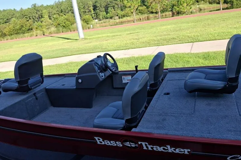 Slide: The Image of 2026 Tracker Bass Tracker Classic XL boat with seating, parked on grass. - 59