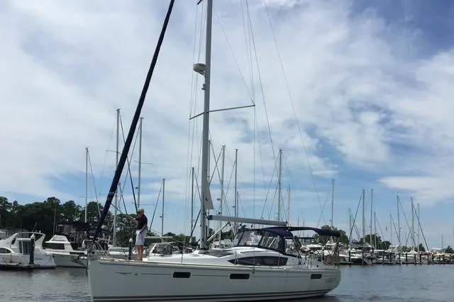 Slide: The Image of 2007 Jeanneau Sun Odyssey 42 DS sailboat docked in a marina under a cloudy sky. - 2