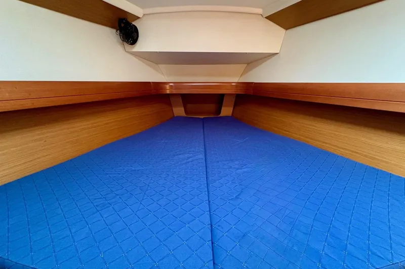 Slide: The Image of 2007 Jeanneau Sun Odyssey 42 DS cabin with blue bedding and wooden interior. - 35