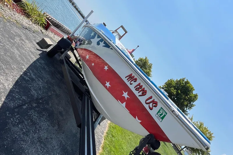 Slide: The Image of Patriot boat with American flag design on trailer by the water, 2021 model. - 11
