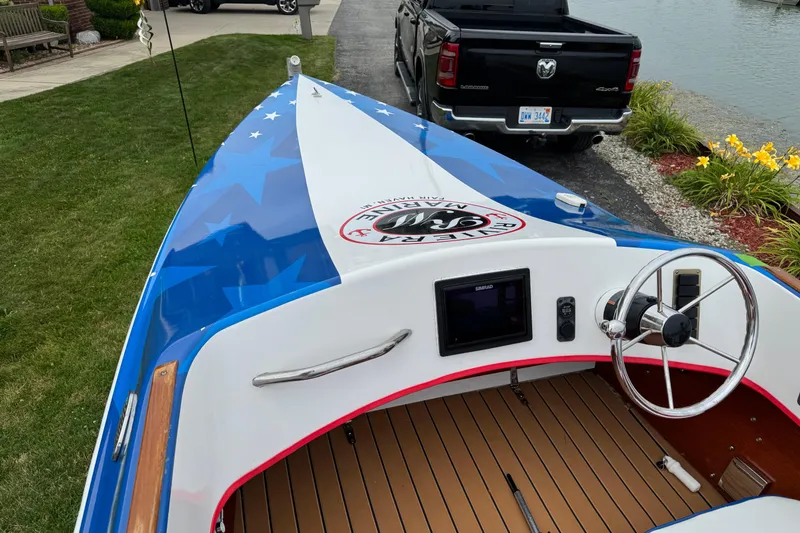 Slide: The Image of Custom 2021 boat with blue and white design, steering wheel, and dashboard, parked near a black truck. - 15