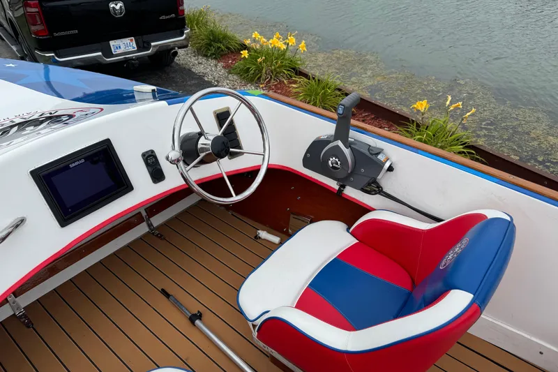 Slide: The Image of Custom 2021 boat interior with red, white, and blue seat, steering wheel, and control panel. - 17