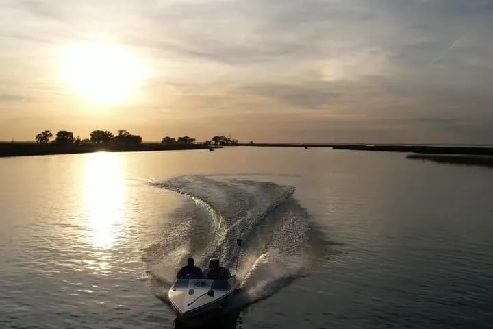 Slide: The Image of Boat cruising on a calm lake at sunset, creating a gentle wake. - 5