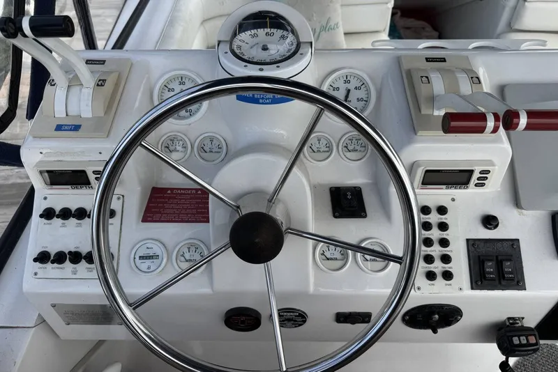 Slide: The Image of Control panel of a 1998 Mainship 31 Sedan Bridge boat with steering wheel and gauges. - 11