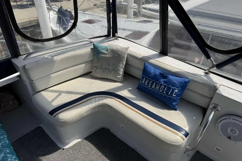 Slide: The Image of 1998 Mainship 31 Sedan Bridge interior with cushioned seating and decorative pillows. - 12