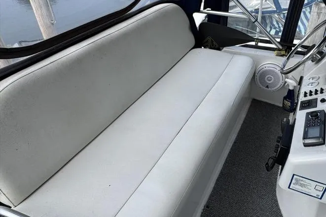 Slide: The Image of 1998 Mainship 31 Sedan Bridge interior with white seating and control panel. - 13