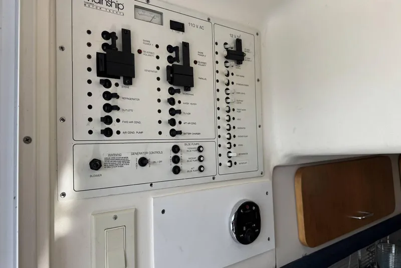 Slide: The Image of Control panel of a 1998 Mainship 31 Sedan Bridge boat, featuring various switches and gauges. - 16