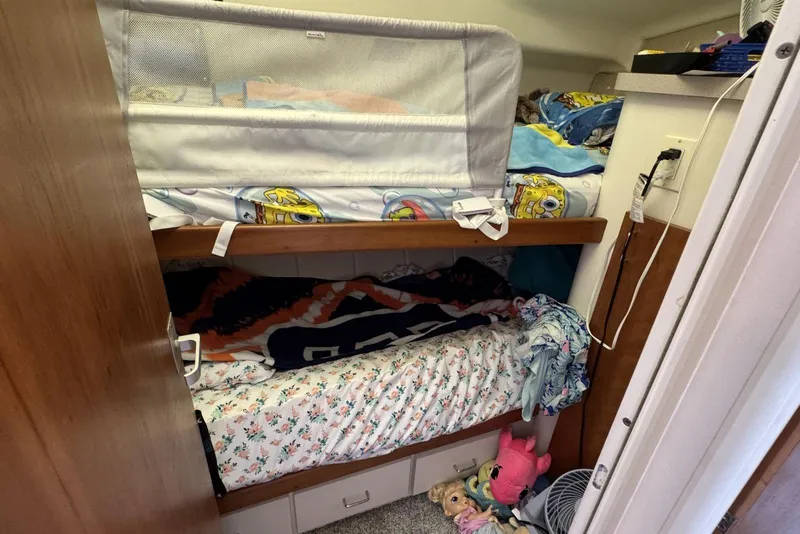 Slide: The Image of Bunk beds in 1998 Mainship 31 Sedan Bridge cabin with colorful bedding and toys. - 18