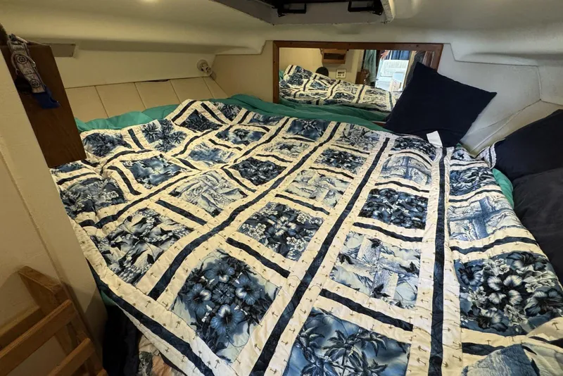 Slide: The Image of Cozy cabin interior of 1998 Mainship 31 Sedan Bridge with floral quilted bedding. - 19