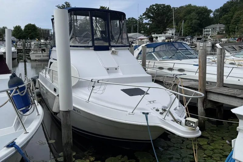 Slide: The Image of 1998 Mainship 31 Sedan Bridge docked at a marina, surrounded by other boats. - 2