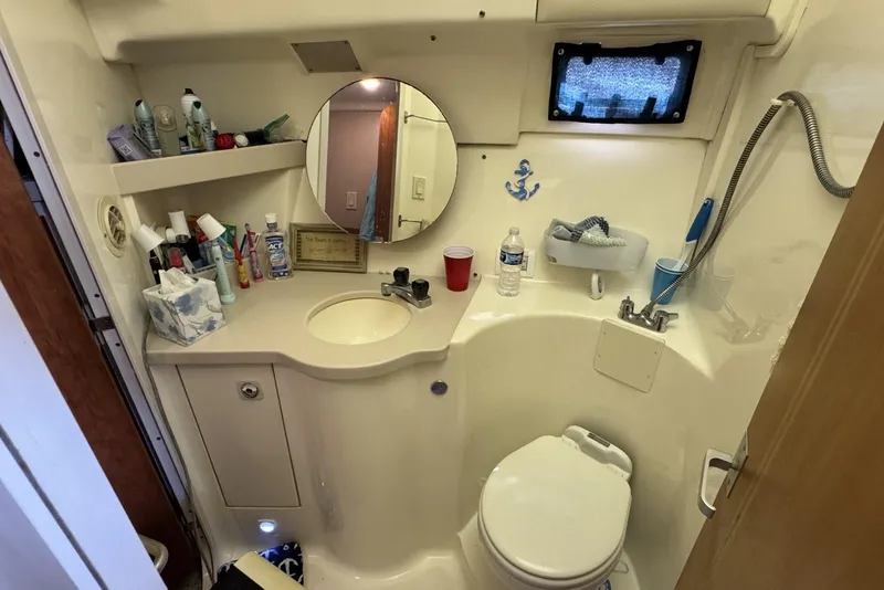 Slide: The Image of Bathroom of 1998 Mainship 31 Sedan Bridge with sink, mirror, and toiletries. - 20