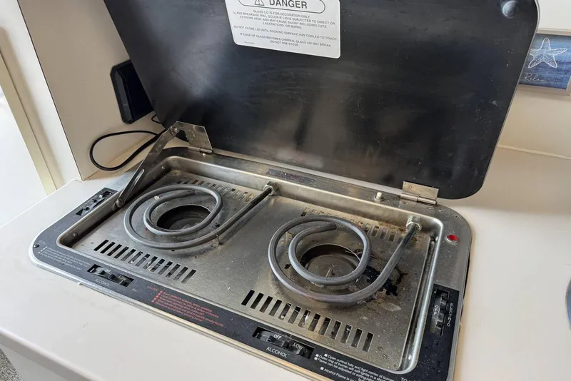 Slide: The Image of Electric stove on 1998 Mainship 31 Sedan Bridge boat, featuring dual coil burners. - 22