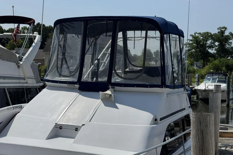 Slide: The Image of 1998 Mainship 31 Sedan Bridge boat docked at marina, featuring enclosed bridge. - 3