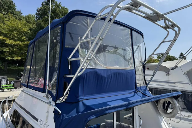 Slide: The Image of 1998 Mainship 31 Sedan Bridge with blue canvas enclosure and stainless steel frame. - 4